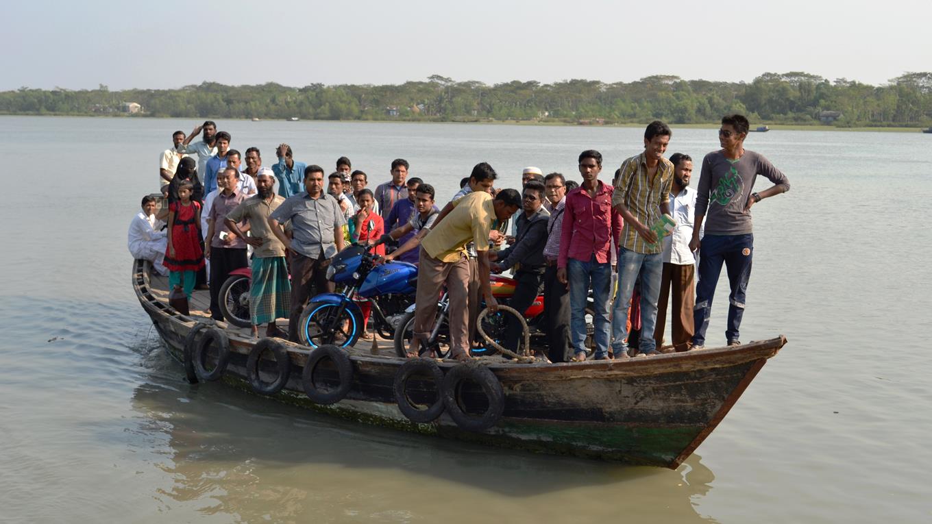Lots of people on a small boat with their motorbikes waiting to disembark